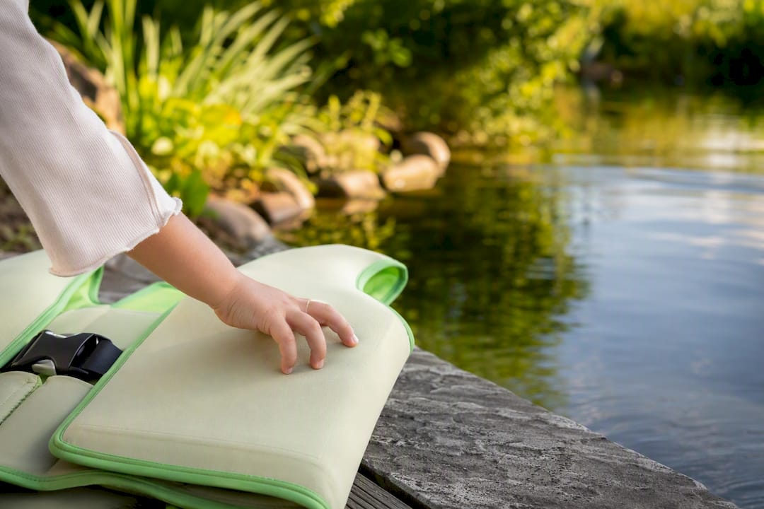 Kinderhand berührt Schwimmring am Beckenrand